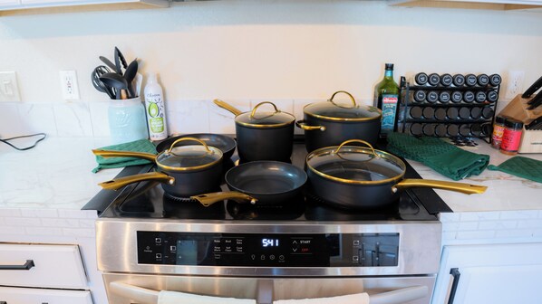 A kitchen with a stove, pots, pans, and a digital clock displaying 5:41.