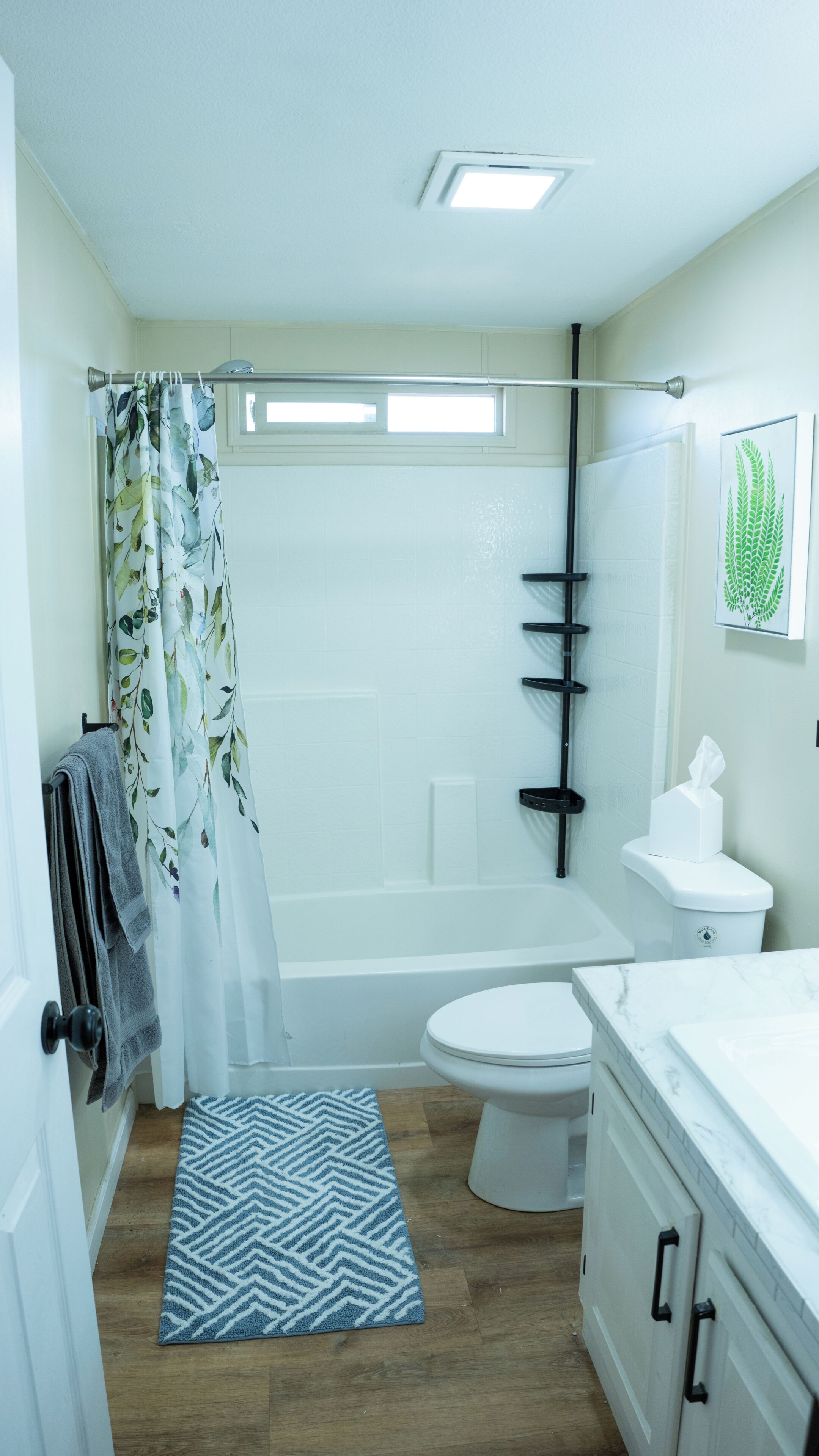 Un baño con bañera, inodoro y cortina de ducha.