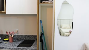 Eine kleine Küche mit weißen Schränken, einer Arbeitsplatte aus Granit und einem Einbauofen.