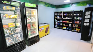 Ein Kiosk mit Kühlregalen, Regalen voller Snacks und einer Auswahl an Getränken.