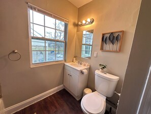 Un baño con inodoro, lavamanos y ventana.
