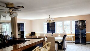 A spacious kitchen with a marble floor, a central island with bar stools, and a dining area with a chandelier. - Beautiful 5-bedroom house with AC in wonderful Bay Shore (Bay Shore)