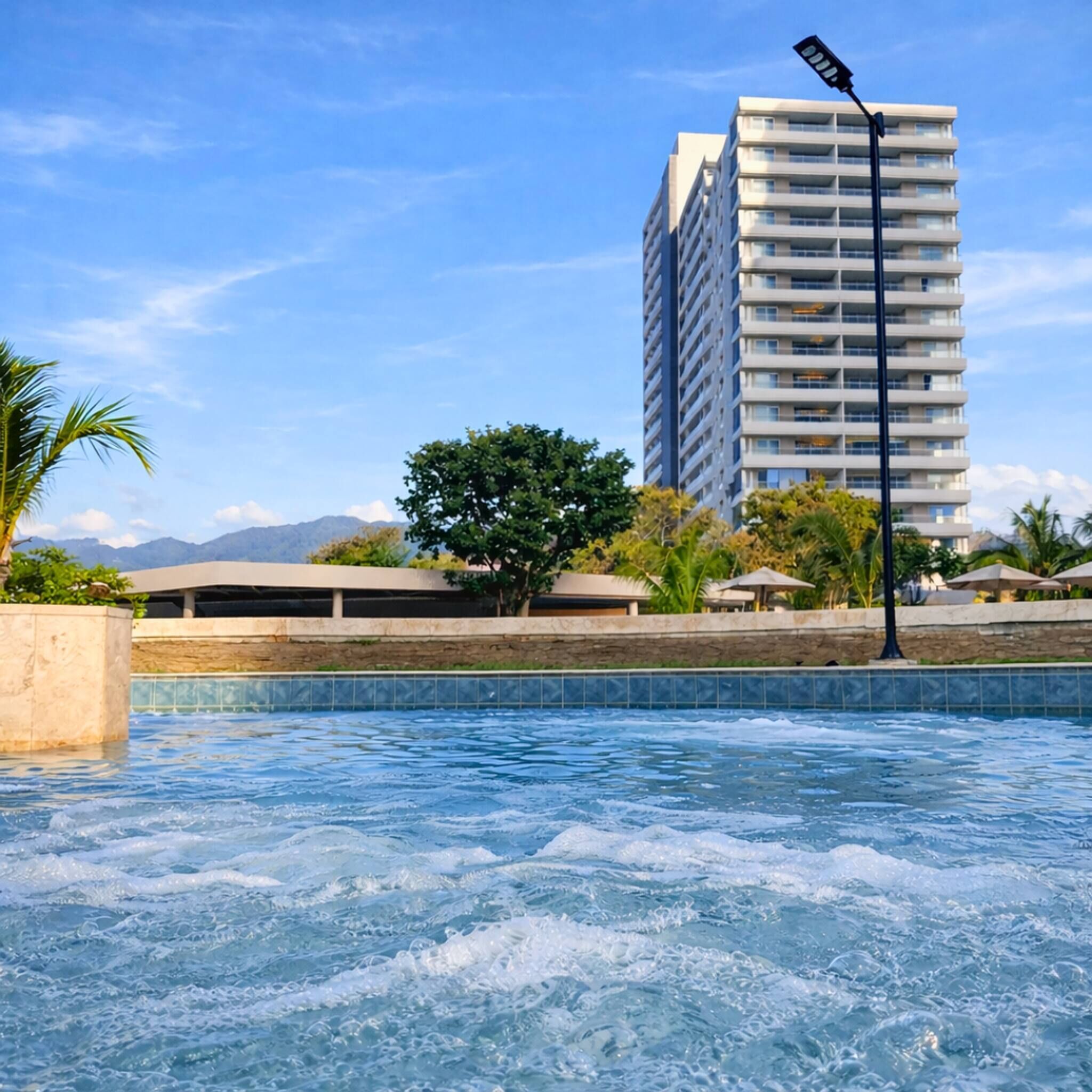 A swimming pool with a view of a tall building in the background.