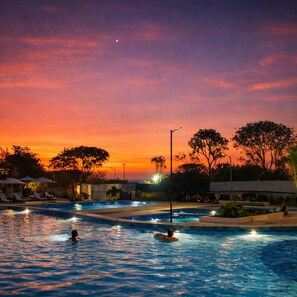 A swimming pool area with multiple lanes, surrounded by trees and lounge chairs. - Ocean View 14th Floor Pools & Beach (Santa Marta)