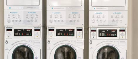 Three stacked washing machines with control panels and digital displays.