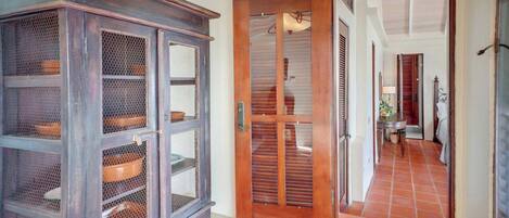A hallway with a wooden door leading to a dining area.