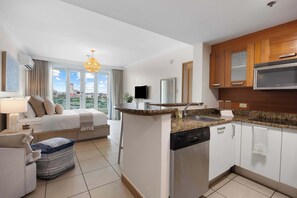 A modern kitchen with a central island, a built-in dishwasher, and wooden cabinets. - 3BR Lagoon Front Apartment - 2 Private Balconies (San Juan)