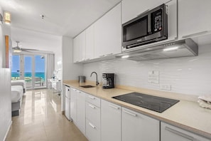 A modern kitchen with a microwave, coffee maker, and a view to the outside. - Lagoon View 3BR - 3 Balconies & Pool (San Juan)