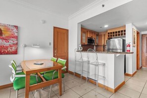 A modern kitchen with a central island, bar stools, and a dining table with chairs. - Lagoon Front 3BR - Balconies & Pool (San Juan)