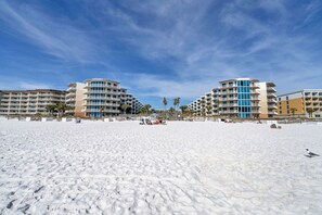 A beachfront hotel with multiple balconies, a sandy beach in the foreground, and palm trees in the background. - 🦩Book Me Baby! Gulf-Front Waterscape B507 Off The Hook🦩 (Fort Walton Beach)