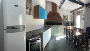 Cuina amb nevera, fogó i forn de rajola.