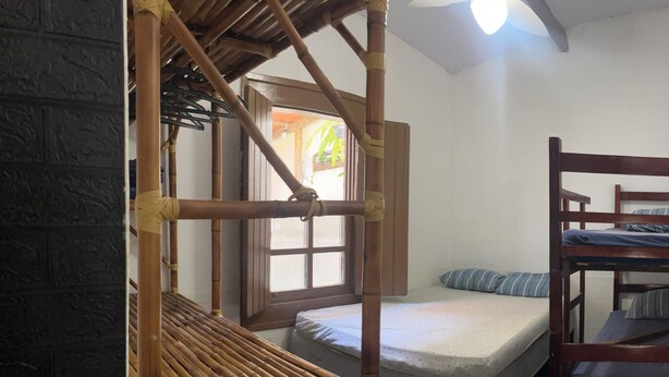 Una habitació amb un llit superposat, una taula petita i una finestra.