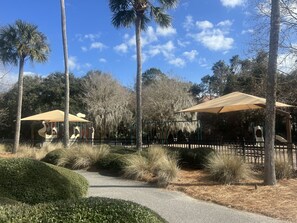 A park with a playground, palm trees, and a covered seating area. - The Retreat by Sandpiper | Near Beach (Seabrook Island)