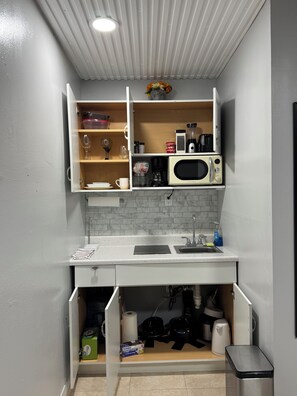 A compact kitchenette with a microwave, coffee maker, and storage cabinets. - Enjoyable 1-bedroom studio with AC in West Palm Beach (West Palm Beach)
