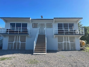 A two-story building with a central staircase, balconies, and large windows. - Rico Puerto Magic Spot East (Cabrera)