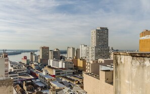 Un paisaje urbano con diversos edificios, entre ellos un edificio alto de diseño llamativo y varias construcciones más bajas.