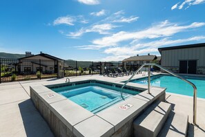 A swimming pool with a metal ladder, lounge chairs, and a fenced area. - Min to Deer Valley East Newest Terrain, Community Amenities, Free Ski Shuttle (Heber City)