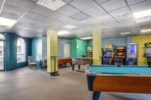 A room with a pool table, arcade games, and a billiards table. - Surfin' Turtle | Oceanfront St. Regis Condo with Balcony, Pool & Resort Amenities (North Topsail Beach)