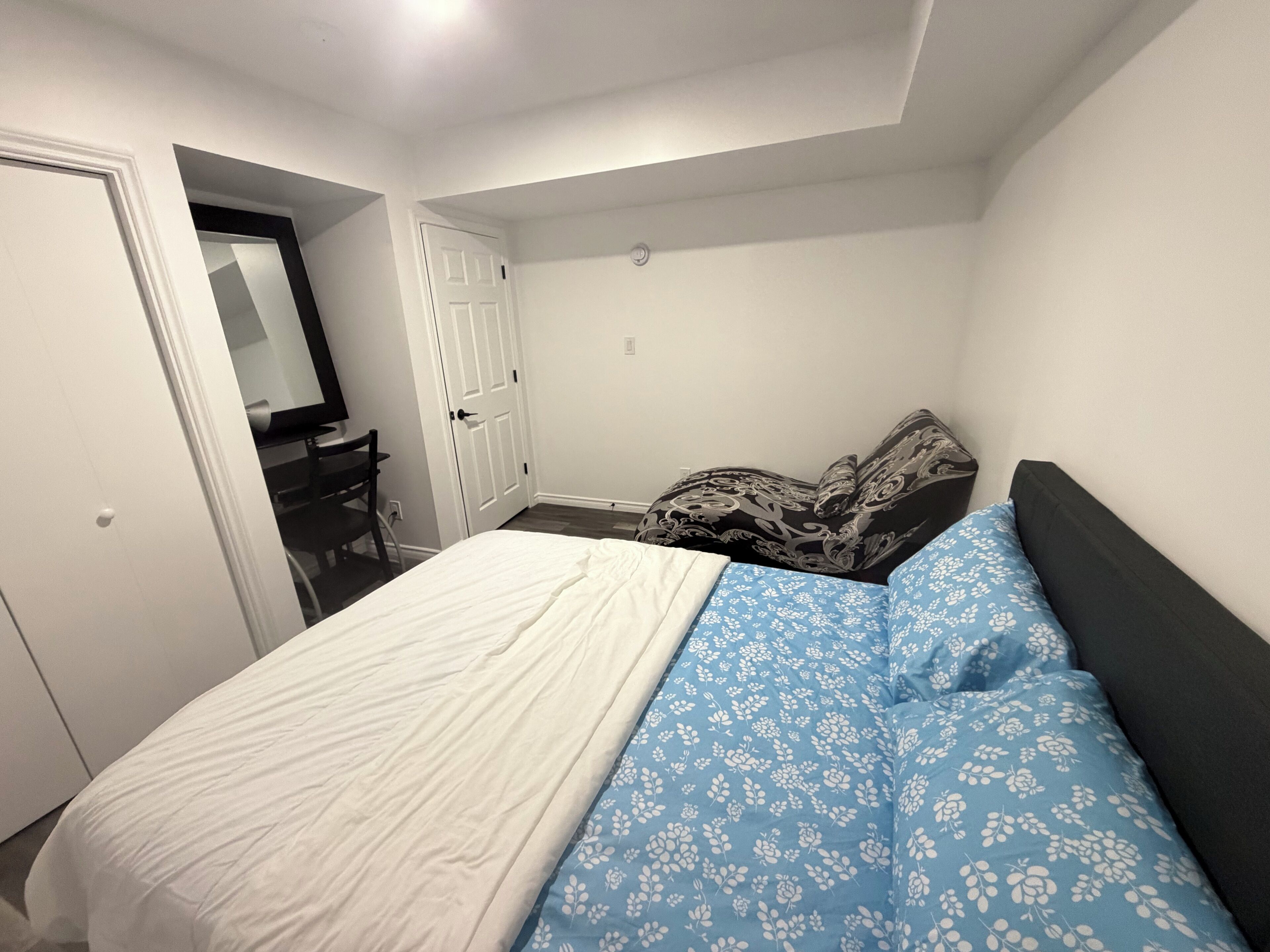Une chambre à coucher avec un lit, un bureau et une porte.