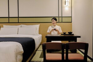 A hotel room with a bed, a table with a tea set, and two chairs. - Mitasuya Ryokan Dongducheon Soyosan (Dongducheon)