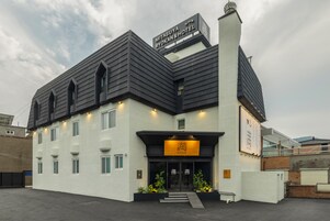 Un hotel con diseño moderno, que destaca un letrero llamativo y una entrada bien iluminada.