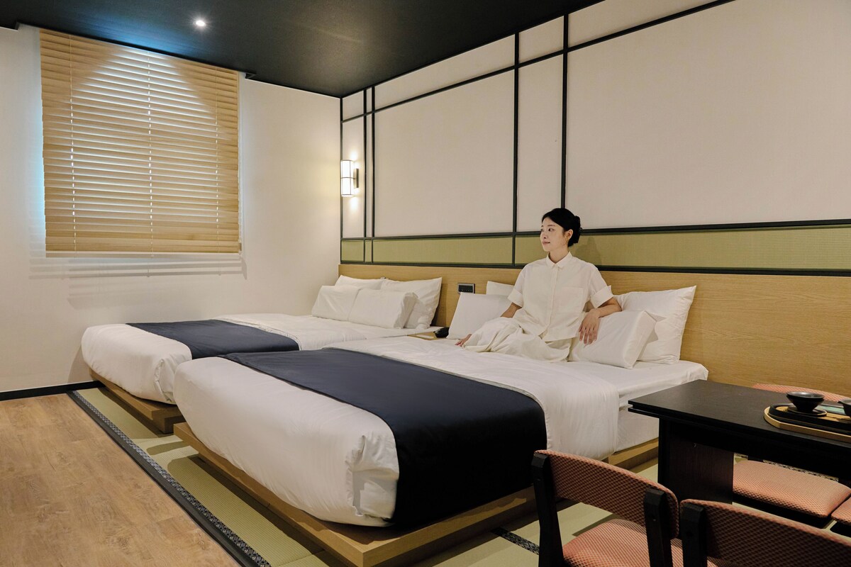 Una habitación de hotel con dos camas, un escritorio y una silla.