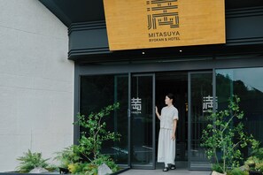 L’entrée d’un hôtel au design moderne, avec une grande porte vitrée et une signalétique.