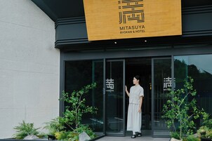 Entrada de hotel con diseño moderno, que presenta un amplio escaparate de vidrio y señalización.