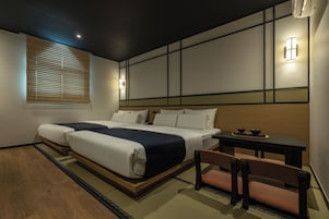 Una habitación de hotel con una cama grande, una mesita pequeña y una silla.