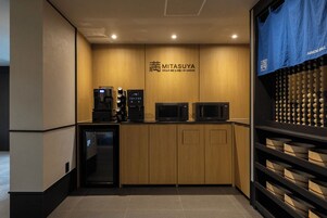 Una kitchenette equipada con cafetera, microondas y refrigerador.