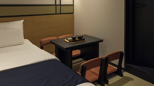 A hotel room with a bed, a small table with a tea set, and two chairs. - Mitasuya Ryokan Dongducheon Soyosan (Dongducheon)