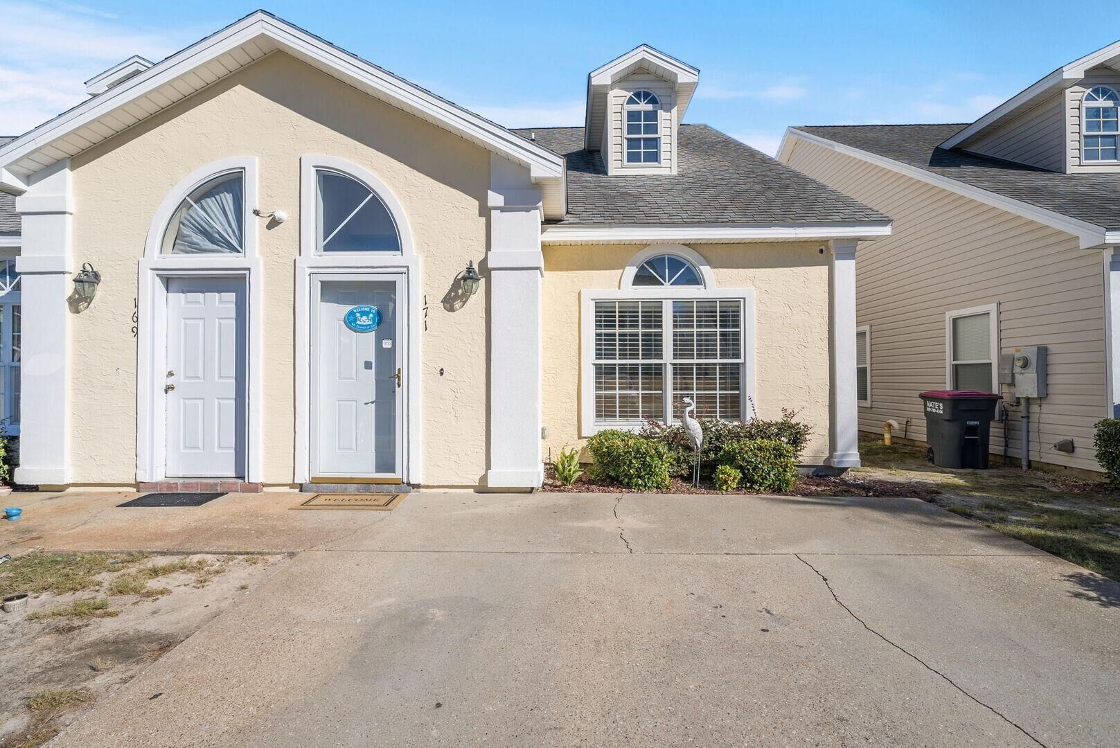 A residential house with a front entrance, two doors, a small porch, and a mailbox.