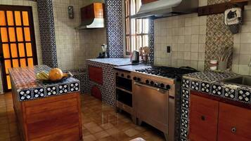 A kitchen with a central island, wooden cabinets, and patterned tile backsplash.