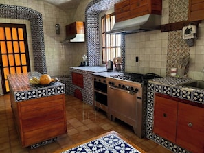 A kitchen with a central island, wooden cabinets, and patterned tile backsplash. - Lovely 1-bedroom hotel in Cuernavaca perfect for your getaway (Cuernavaca)