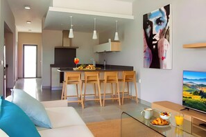 A modern living room with a sofa, a coffee table, and a TV. - Villa Garden House Gh06, Pool & Holidays, 2 Min To Beach (Mont Choisy)