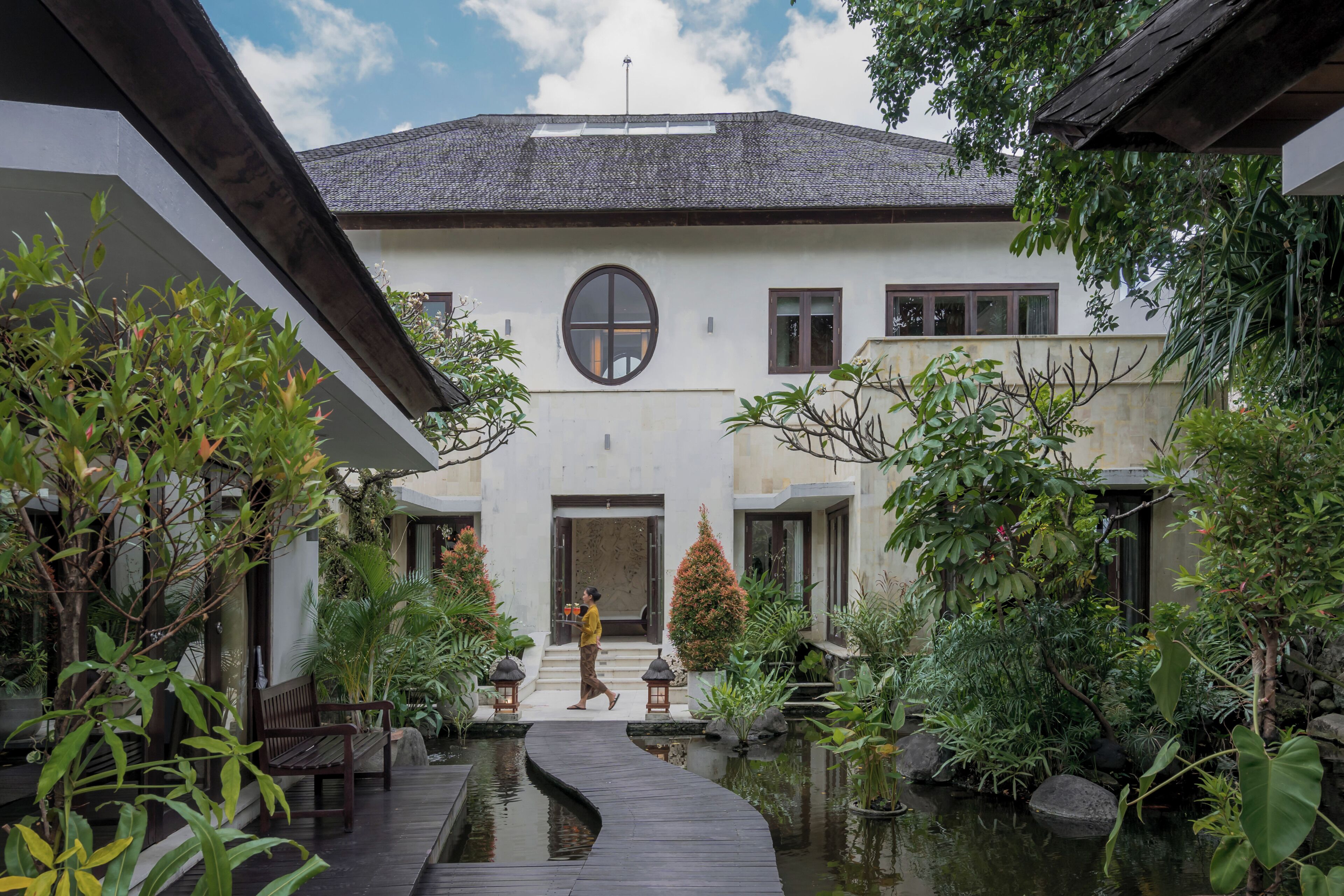 Il s’agit d’un bâtiment traditionnel doté d’une cour intérieure, d’une passerelle en bois et d’un élément décoratif aquatique.