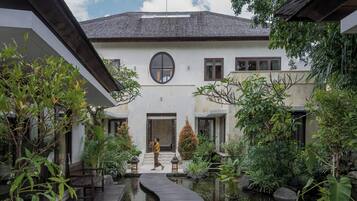 Il s’agit d’un bâtiment traditionnel doté d’une cour intérieure, d’une passerelle en bois et d’un élément décoratif aquatique.