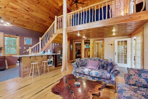 A wooden interior with a staircase, a sofa, and a coffee table.
