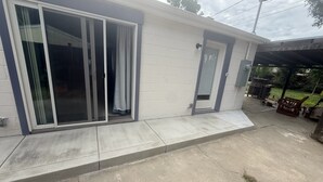 A residential building with a covered patio area, a sliding glass door, and a small door. - Minimalist 1 BR ADU in a pleasant Woodland neighborhood (Woodland)