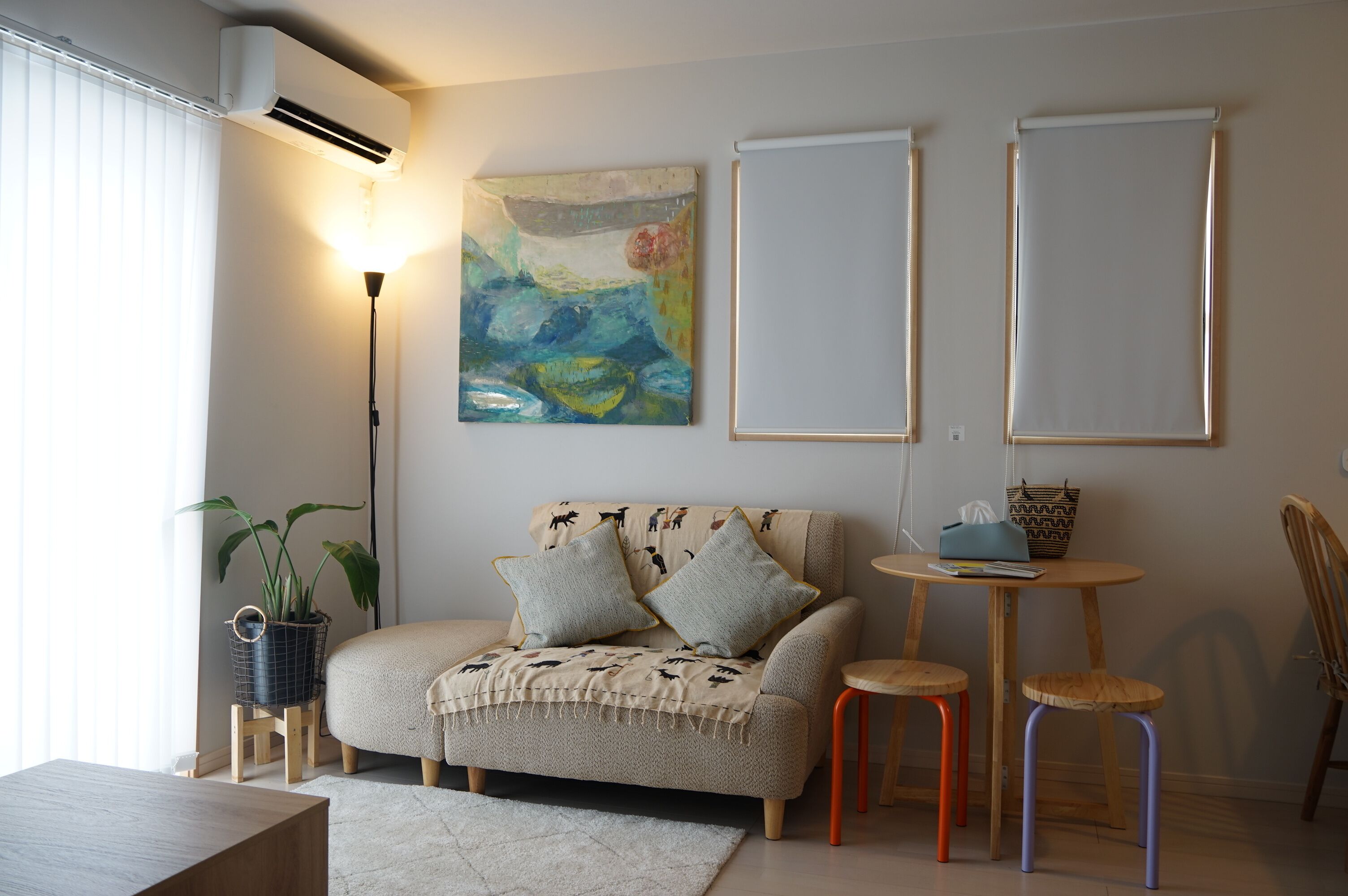 En hyggelig stue med en sofa, et sofabord og en gulvlampe.