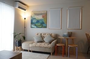 A cozy living room with a sofa, a coffee table, and a floor lamp. - 7-minute drive to Hirome Market / New single-family home / 60 square meters / Sleeps 6 / Free parking   (高知市)