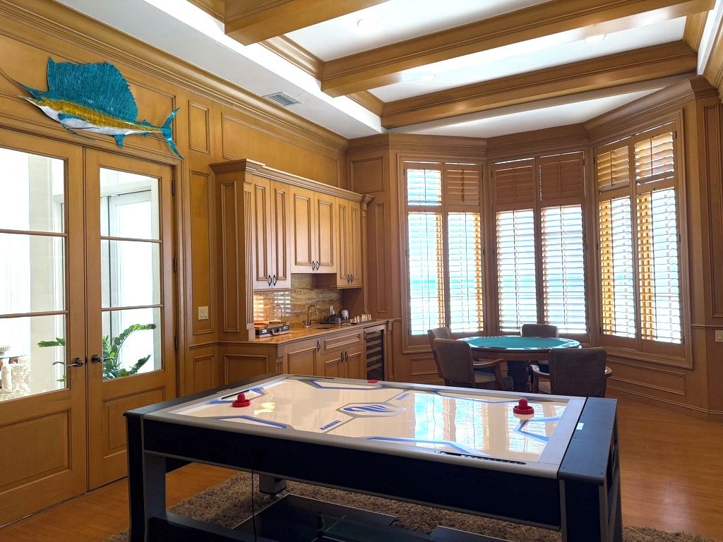 A room with wooden paneling, a pool table, and a large fish decoration.