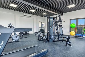 A gym with exercise equipment, a treadmill, and a mirrored wall. - Brand New Walishali 1BR Condo  Close 2 EagleBeach (Noord)