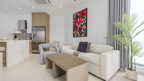 Una sala de estar moderna con sofá, mesa de centro y un ventanal con cortinas.