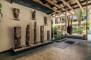 Eine Lobby im modernen Design, mit einer Reihe aus Holzskulpturen und einer Sitzecke mit Schaukelstuhl.