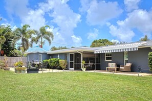 A residential property with a covered patio, outdoor seating, and a barbecue area. - Memories Beach Villa! Near Gulf Beaches + BBQ (Largo)
