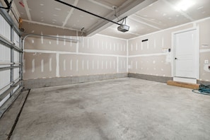 Eine Garage mit ungewollten Wänden, einem Betonboden und einer Tür.