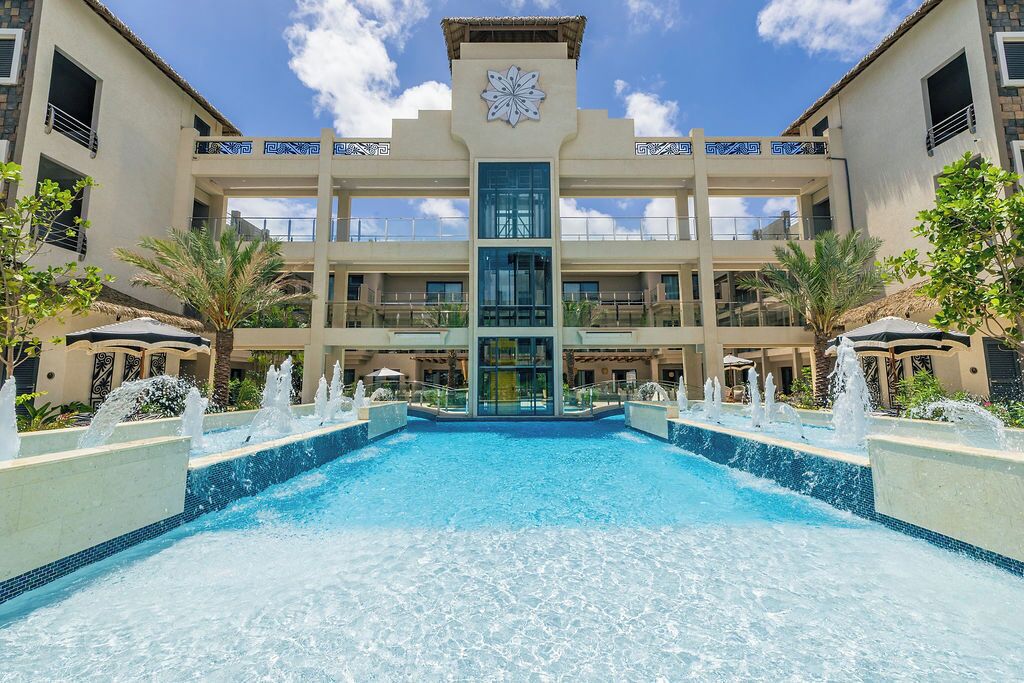 Ein Hotel mit zentralem Pool, mehreren Balkonen und einem markanten architektonischen Design.