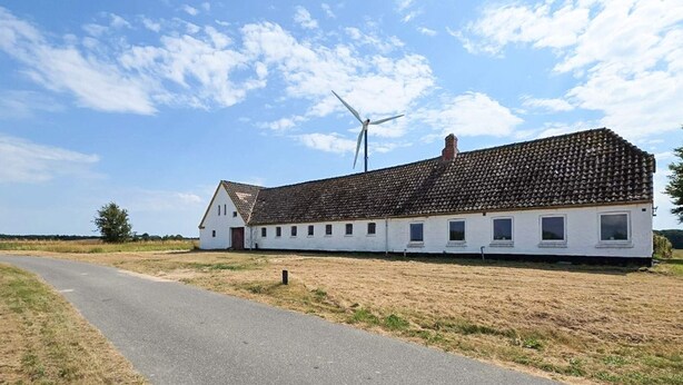 A white building with a tiled roof and a wind turbine in the background. - 2 Person Holiday Home in Vra (Vra)