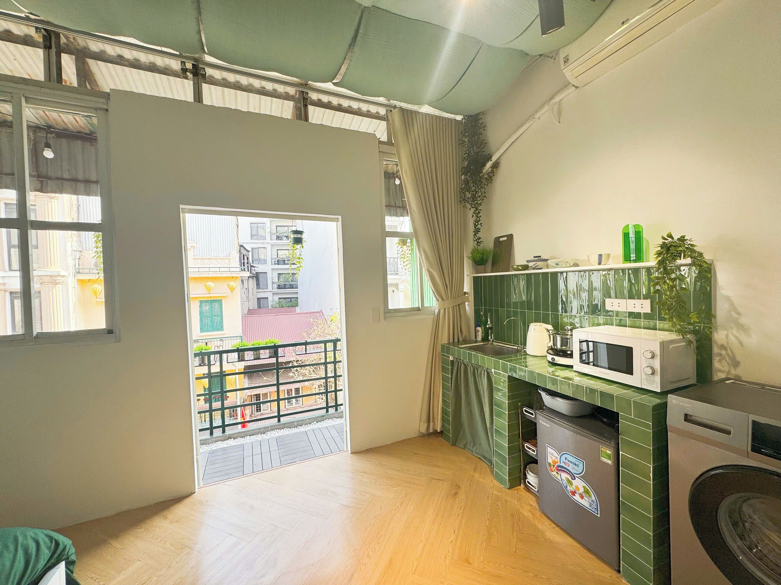 A compact kitchen with a microwave, a washing machine, and a sink.